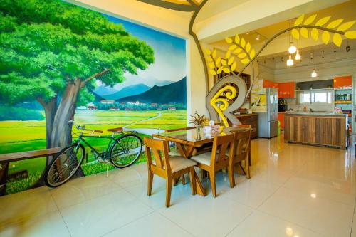 un comedor con una mesa y un mural para bicicletas en Brownbnb, en Chishang