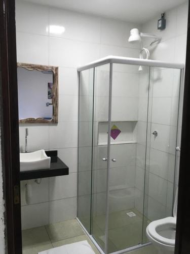a bathroom with a glass shower and a sink at Pousada Brisa e Mar in Praia do Frances