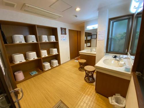 a bathroom with a sink and a counter with a mirror at Atami Onsen Guest House Megumi 5 minutes walk from Atami Station in Atami