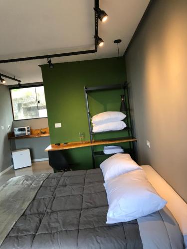 a bedroom with a large bed with a green wall at Rancho dos Pássaros Amarelos in Campestre