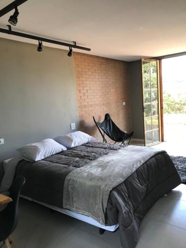 Un pat sau paturi într-o cameră la Rancho dos Pássaros Amarelos