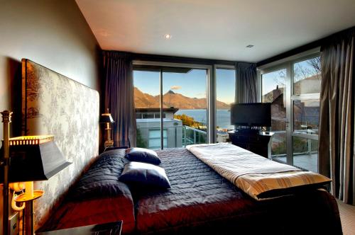 a bedroom with a bed and a large window at 13 Poole Lane by Staysouth in Queenstown