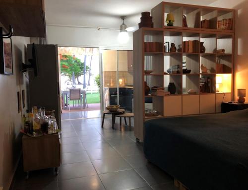 a bedroom with a bed and a room with a kitchen at Beautiful Ground Floor, Seaside Studio Flat in Le Moule