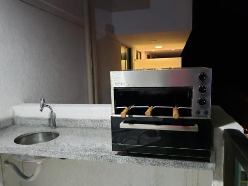 a kitchen counter with a sink and a stove at Laguna Beach Flat 314- Porto de Galinhas in Porto De Galinhas