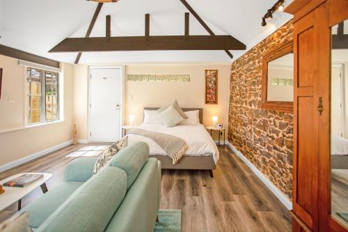 a bedroom with a bed and a stone wall at Settlers Cottage in McLaren Vale