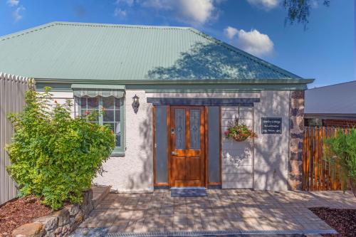 a small white house with a green roof at Settlers Cottage in McLaren Vale