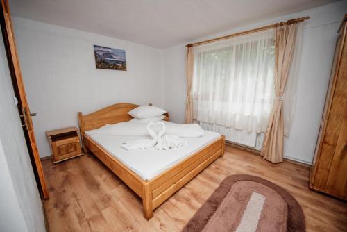 een kleine slaapkamer met een bed en een raam bij Casa Cristalul Muntilor in Poiana Mărului