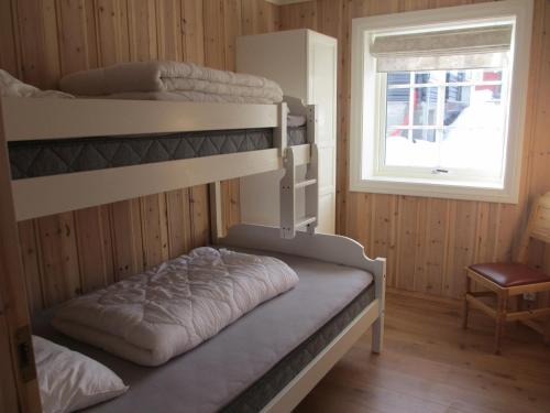 a bunk bed room with two bunk beds and a window at Skåbu Camping in Skåbu