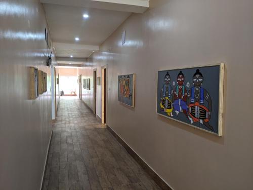 a hallway with paintings of superheroes on the wall at Dip Holidays in Shānti Niketan