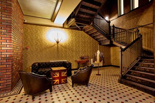 a room with a staircase with chairs and a table at Manufactura Design-Hotel in Khodosovka