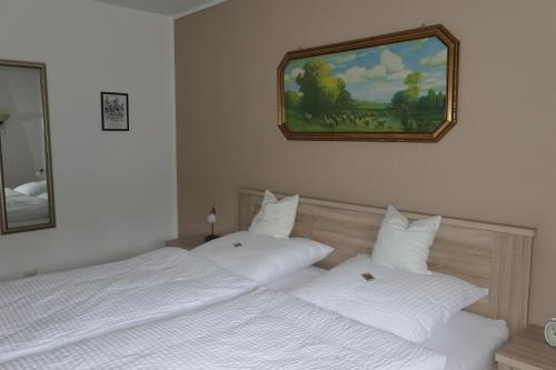 two white beds in a bedroom with a picture on the wall at FEWO Hof Elbbachtal in Westerburg