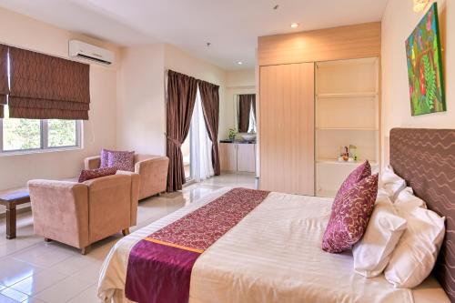 a bedroom with a bed and a couch and a chair at Geopark Hotel Kuah Langkawi in Kuah