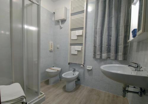 ein Bad mit einem WC, einem Waschbecken und einer Dusche in der Unterkunft Hotel Minerva in Ravenna
