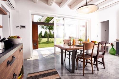 a kitchen and dining room with a wooden table and chairs at B&B BARCO41 in SantʼAngelo di Piove di Sacco