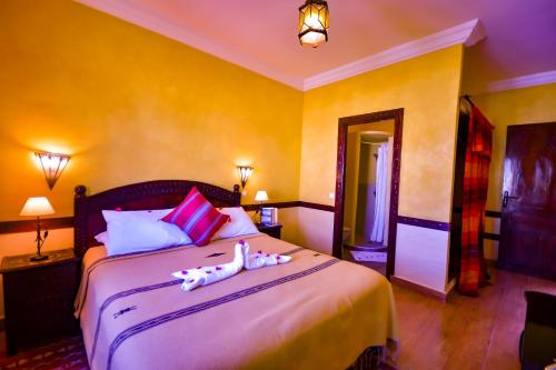 a bedroom with a bed with two dolls on it at Riad Zahra in Essaouira