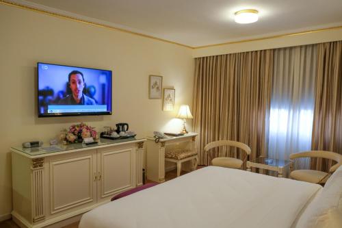 a hotel room with a bed and a flat screen tv at Amman International Hotel in Amman