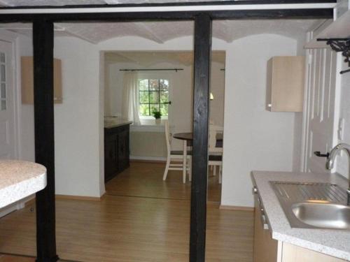 a kitchen with a table and a dining room at Little Rose Cottage - Urlaub unter Reet zwischen den Meeren in Börm