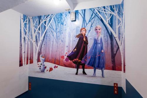 a painting of two women on a wall at Gui Ren Sha Cheng Guest House in Chenggong