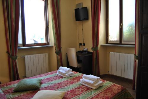 a hotel room with a bed and a television at Hotel Oberje De La Viere in Oulx
