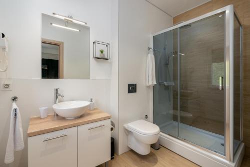 a bathroom with a toilet and a sink and a shower at VILA ROZA in Prožura