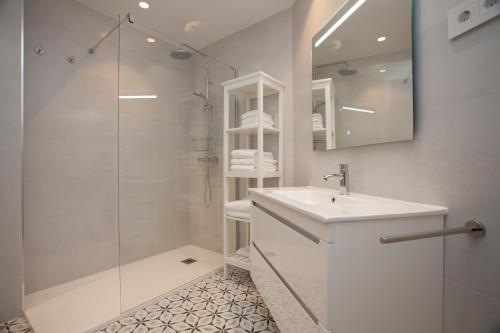 a white bathroom with a sink and a shower at La Casa de Mozo in Avila
