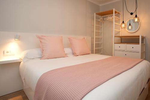 a bedroom with a large bed with pink pillows at La Casa de Mozo in Avila