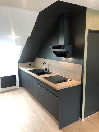 eine Küche mit Spüle und Arbeitsplatte in der Unterkunft Ma Montagne Chic 2 in La Bresse