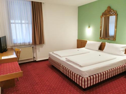 um quarto de hotel com uma cama e um espelho em Landhotel Ölmühle em Mömbris