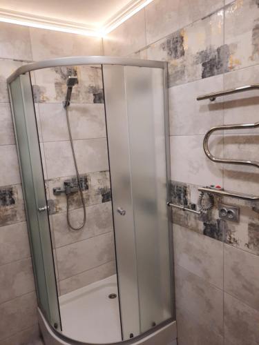 a shower with a glass door in a bathroom at NEW Luxury Studio Apartment in Ivano-Frankivsʼk