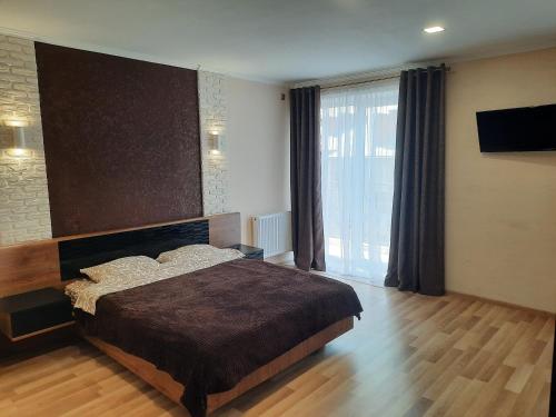 a bedroom with a large bed and a large window at NEW Luxury Studio Apartment in Ivano-Frankivsʼk
