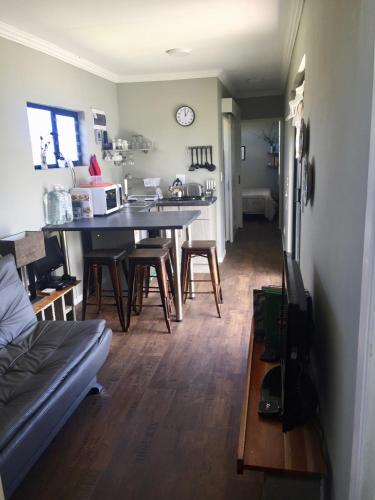 a kitchen and living room with a table and chairs at Casetta del Fuoco - Eco Container Cottage in Plettenberg Bay