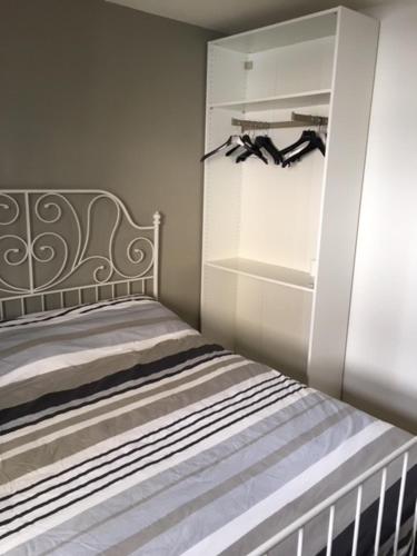 a bedroom with a crib and a white refrigerator at Royal III in Knokke-Heist