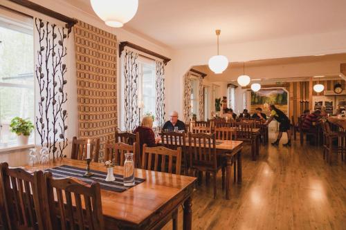 a restaurant with wooden tables and people sitting at tables at Järjagården Hostel in Storsele