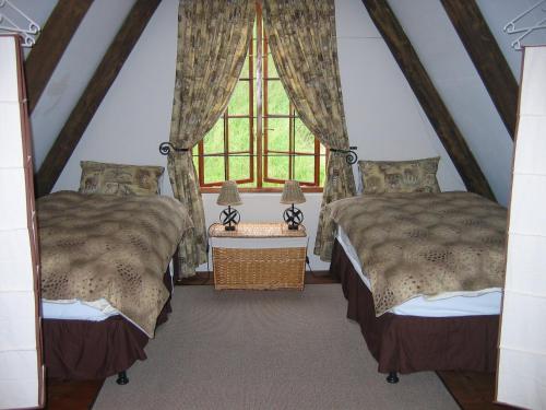 dwa łóżka w pokoju z oknem w obiekcie Bonnie View Game Lodge w mieście Hilton