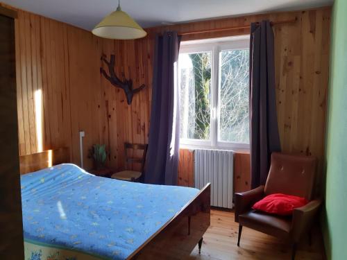 une chambre avec un lit, une fenêtre et une chaise dans l'établissement Au Domaine des oiseaux, à Montredon