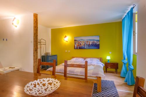 a bedroom with a bed with a yellow wall at BigBlue house Apartman Amelie in Veli Lošinj