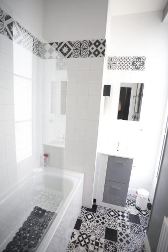 a white bathroom with a tub and a sink at L'APPART LE 5 in Blois