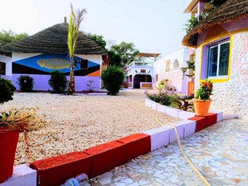 ein Haus mit einem Schlauch vor einem Hof in der Unterkunft Nouvelle vision des coquillages CHEZ NABOU in Toubakouta