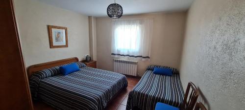 Ares del MaestreにあるApartamento Rural Coll d'Aresのベッド2台と窓が備わる小さな客室です。