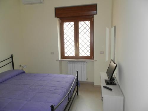 フィウミチーノにあるAppartamento Fiumicinoのベッドルーム(ベッド1台、テレビ、窓付)