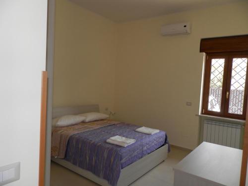 フィウミチーノにあるAppartamento Fiumicinoのベッドルーム1室(ベッド1台、タオル2枚付)