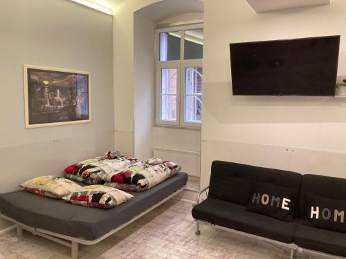 a living room with a couch and a flat screen tv at Marilyn City Center in Pécs