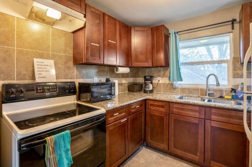a kitchen with wooden cabinets and a stove top oven at East Downtown Bungalow in Houston