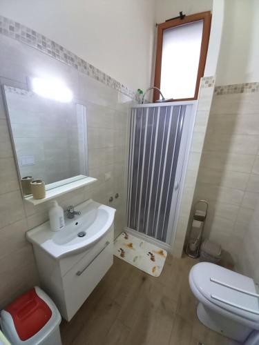 a bathroom with a sink and a toilet and a mirror at Bella Reggio in Reggio di Calabria