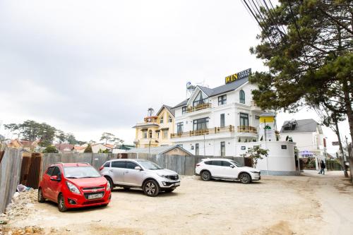 three cars parked in front of a white building at Win Villa Coffee in Da Lat