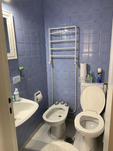a blue bathroom with a toilet and a sink at Mirador de Plaza España in Cordoba