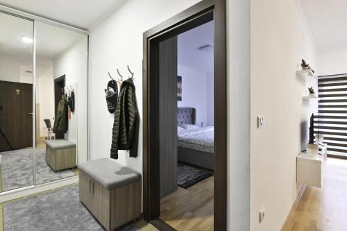 a room with a mirror and a bedroom with a bed at Zova Deluxe Apartment in Zlatibor