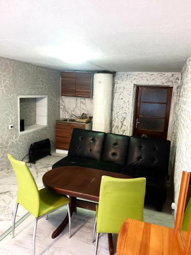 ein Wohnzimmer mit einem Sofa, einem Tisch und Stühlen in der Unterkunft 2 стаен до парка in Razgrad
