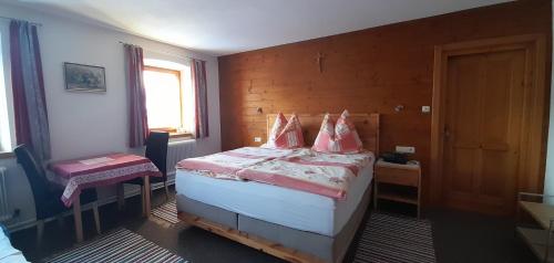 Privatzimmervermietung Foidlbauer في أوبيرندورف إن تيرول: غرفة نوم مع سرير مع وسائد وردية عليه