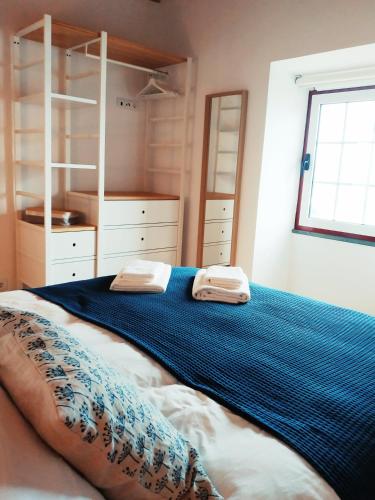 a bedroom with a bed with two towels on it at Janela do Porto in Prainha de Baixo